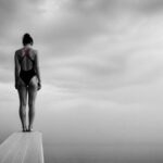 Donna sul trampolino che esita prima del tuffo: la paura di sbagliare